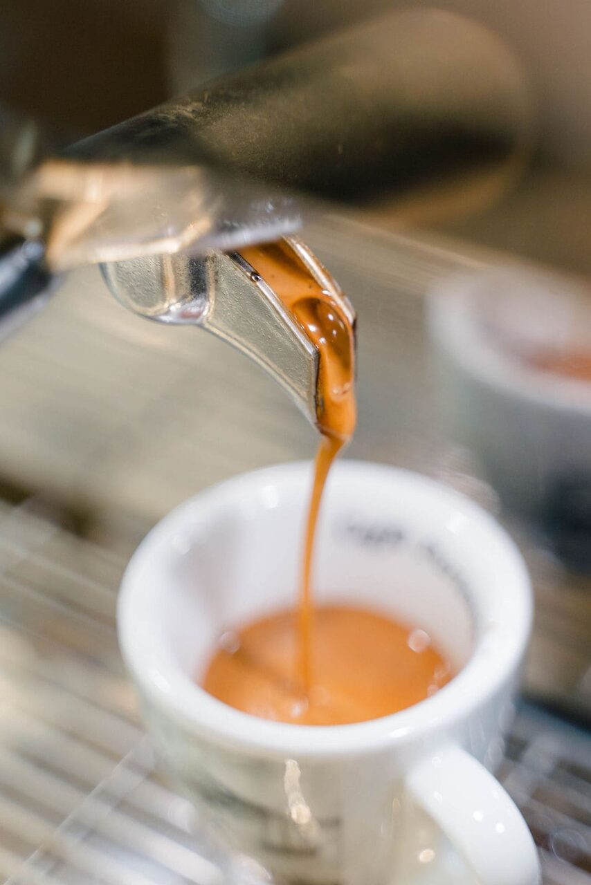Freshly prepared espresso pouring into a cup