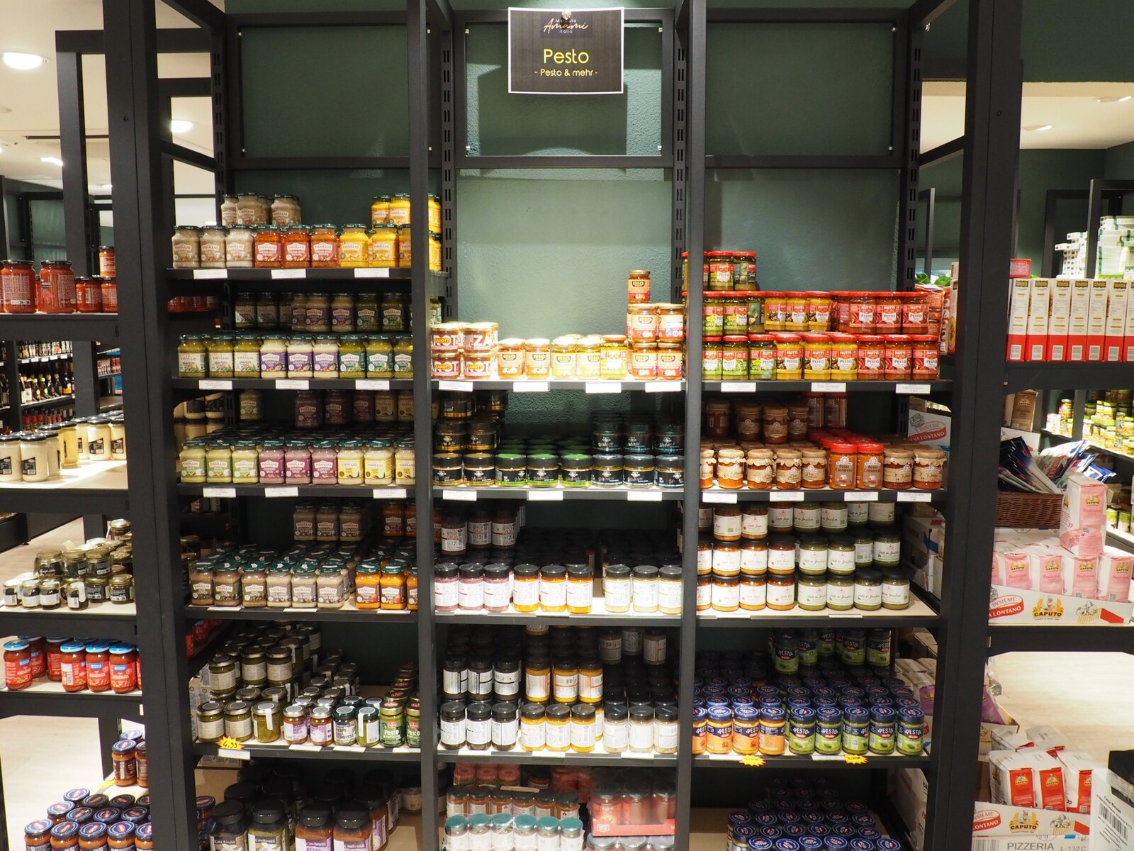 Shelves of Italian pesto and delicatessen products at Mercato Amami Italia